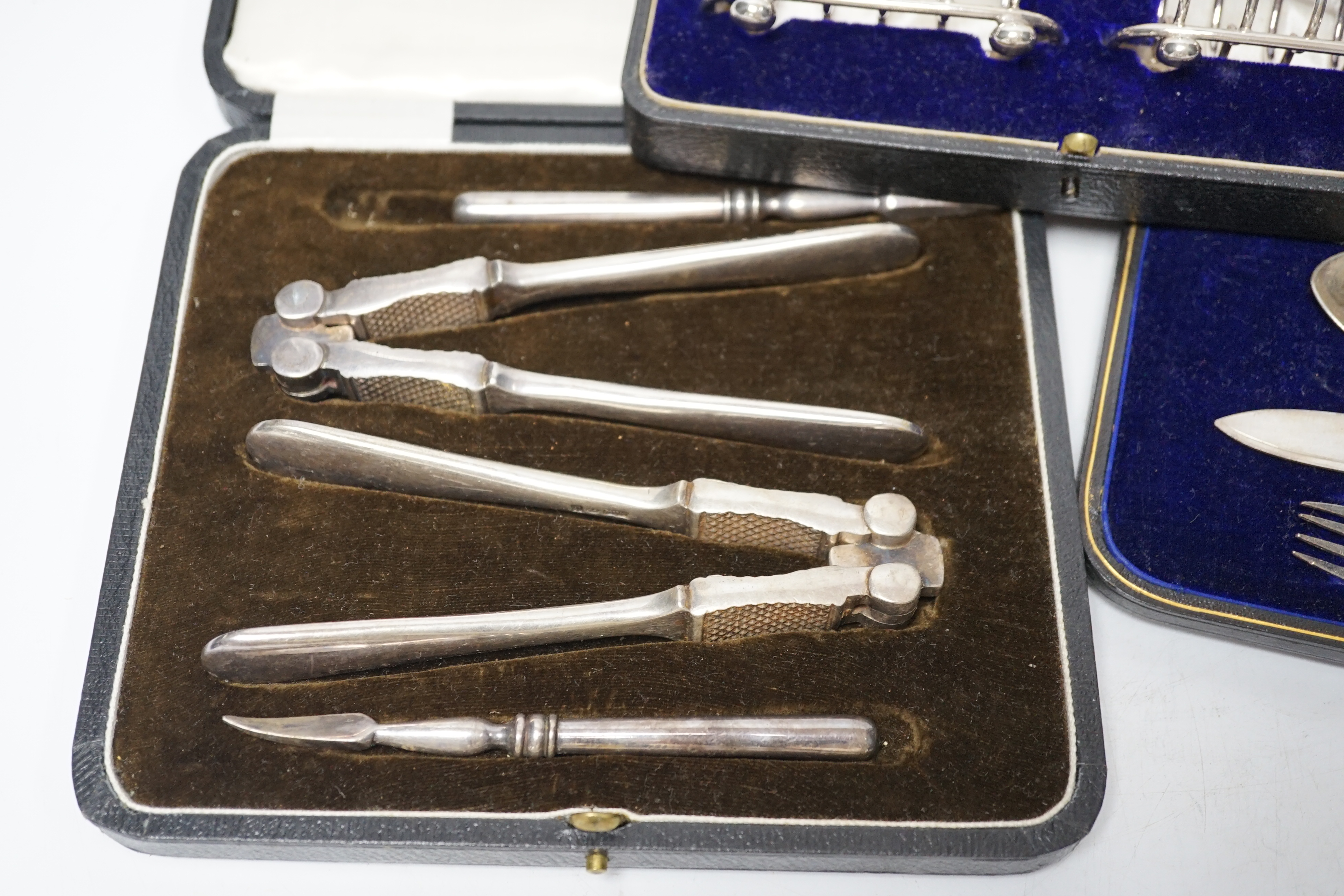 Thirteen assorted cased silver sets, including two sets of six handled tea knives, Leicester and Pudsey replica spoons, two matched sets of napkin rings, single spoon, christening trio, two sets of teaspoons, pair of toa